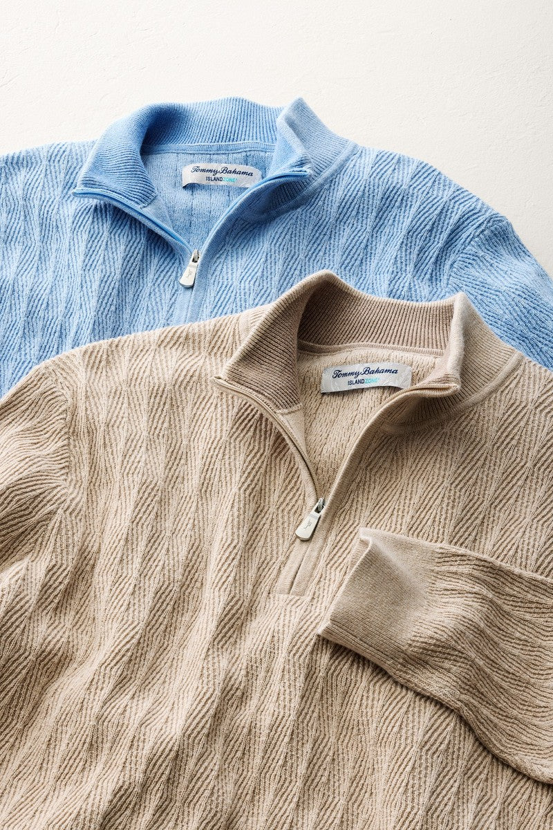 Two quarter-zip sweaters, one blue and one beige, on a light background.